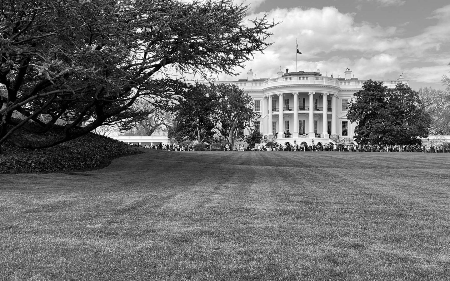 black and white photo of The White House sitting behind a lawn
